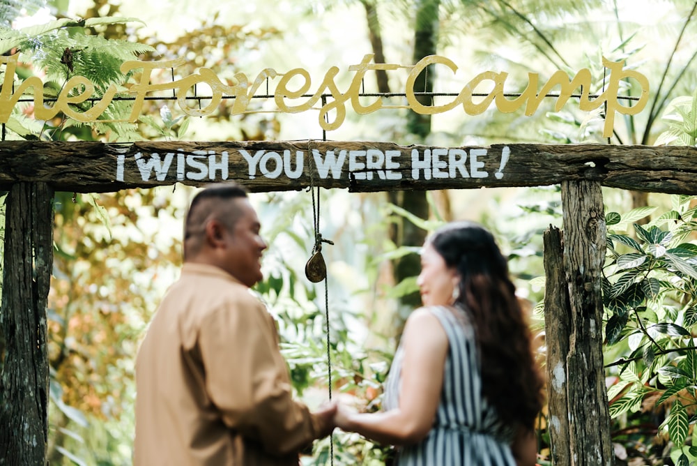 a man and a woman standing under a sign