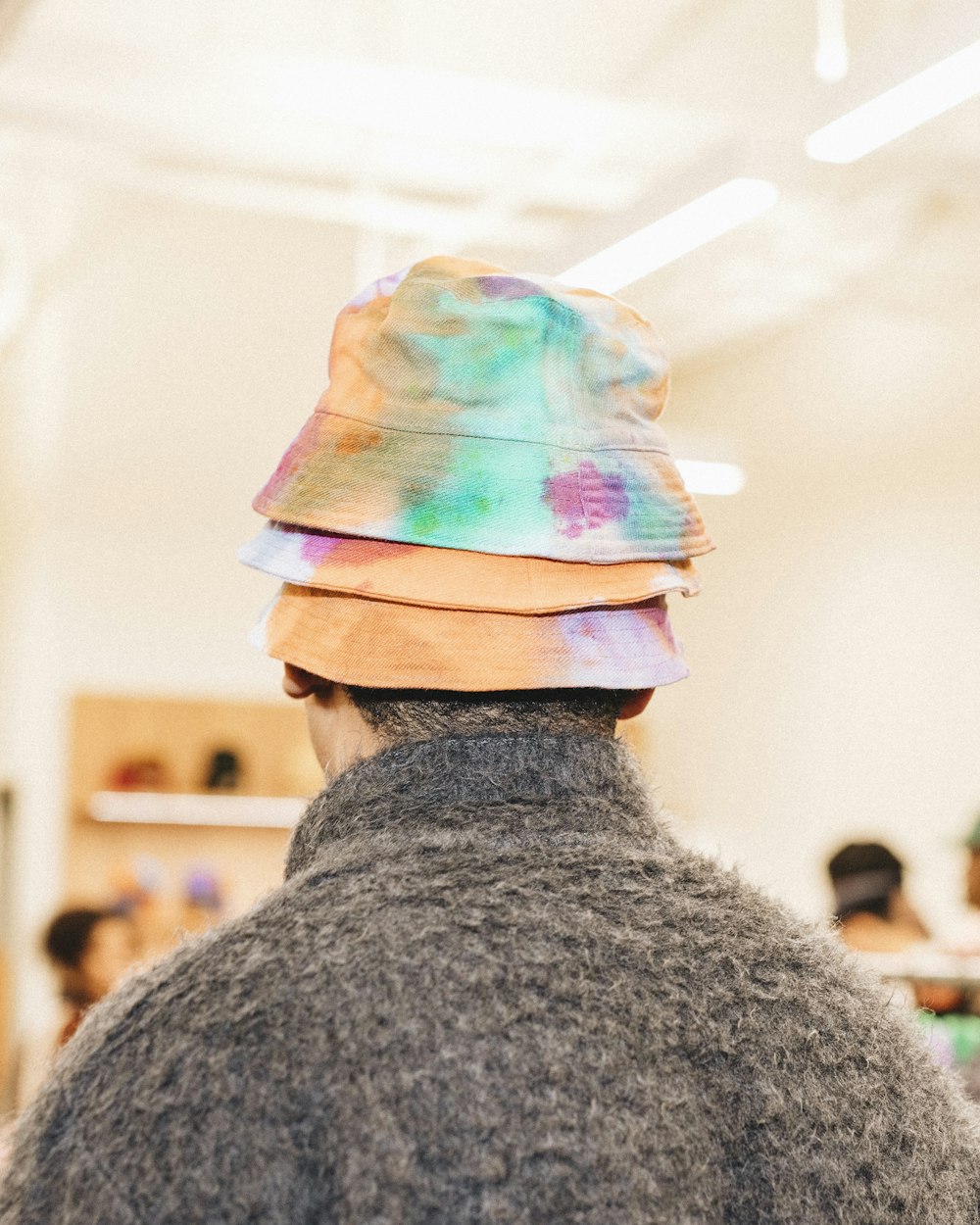 a person wearing a hat with a tie dye pattern on it