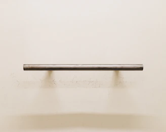A delicate key hanger mounted on a charcoal grey wall, highlighting fine joinery.