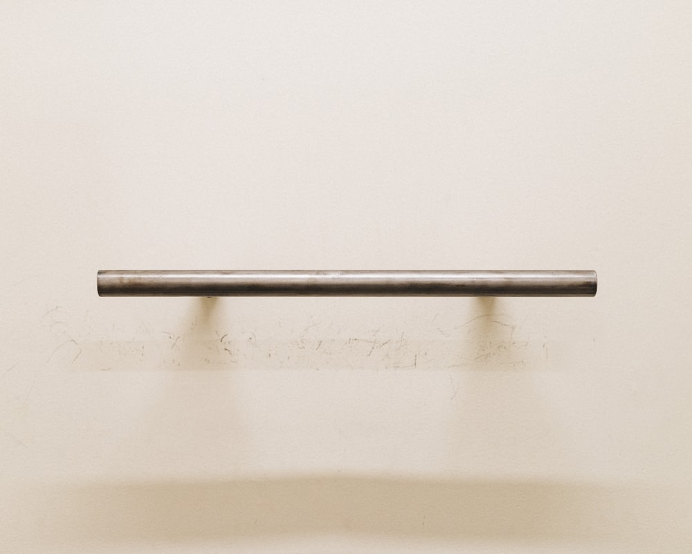a metal bar mounted to a white wall