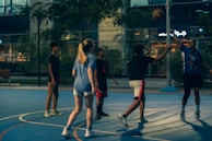 a group of young people playing a game of basketball