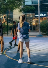 A group of young athletes practicing basketball drills on an outdoor court.