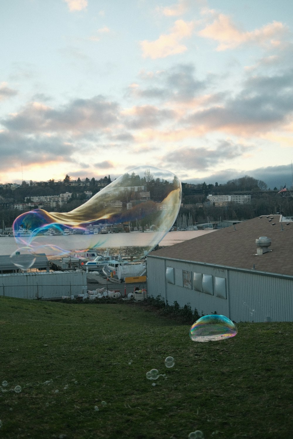 a large kite flying over a lush green field