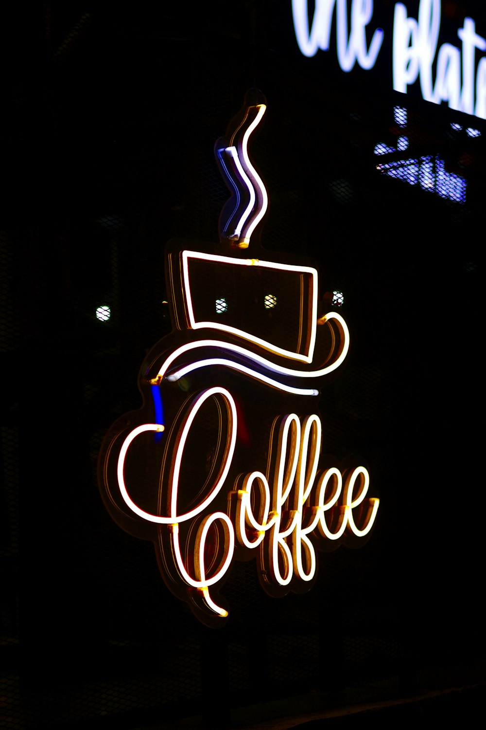 a lit up coffee sign in the dark