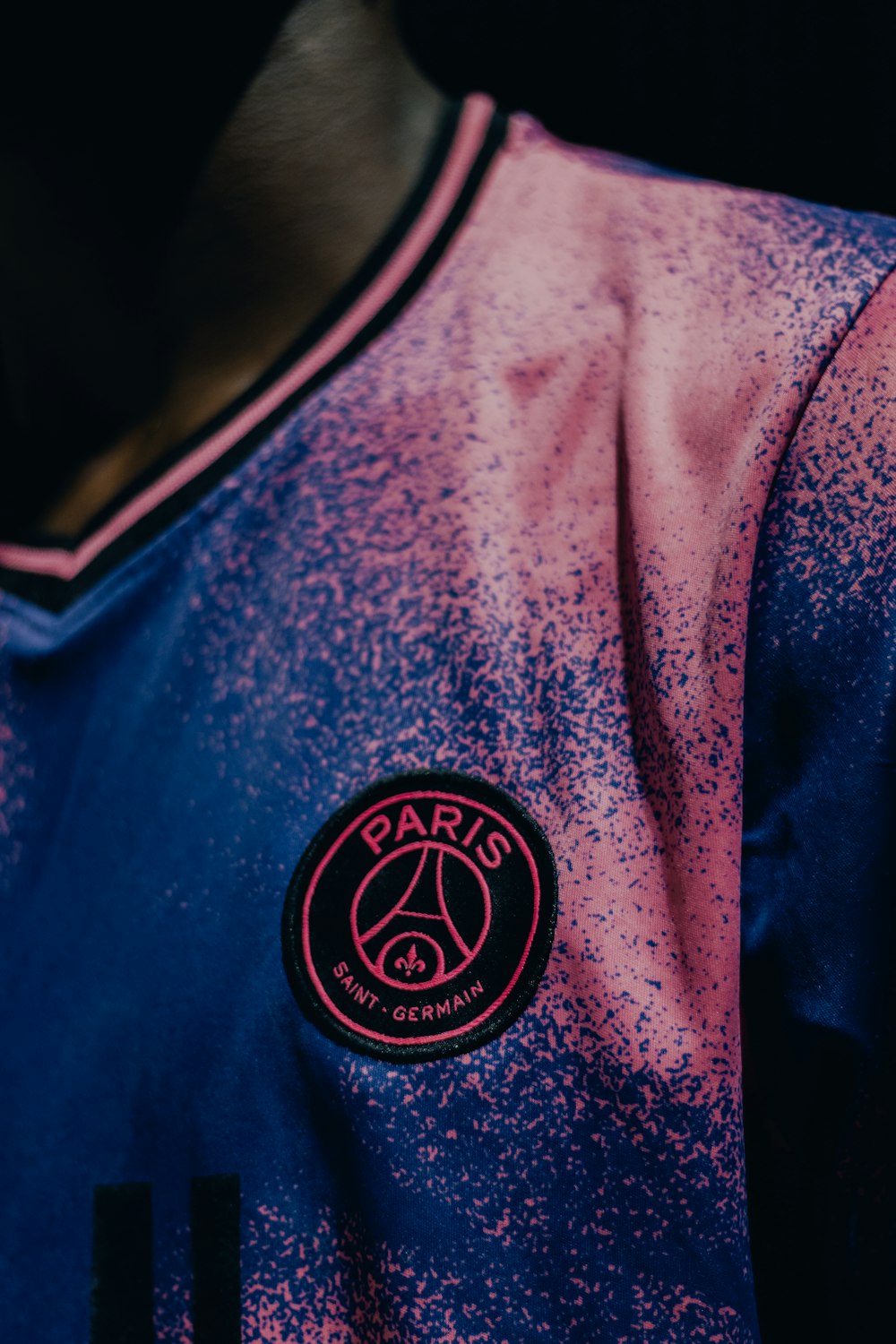 a close up of a soccer jersey with pink and blue speckles
