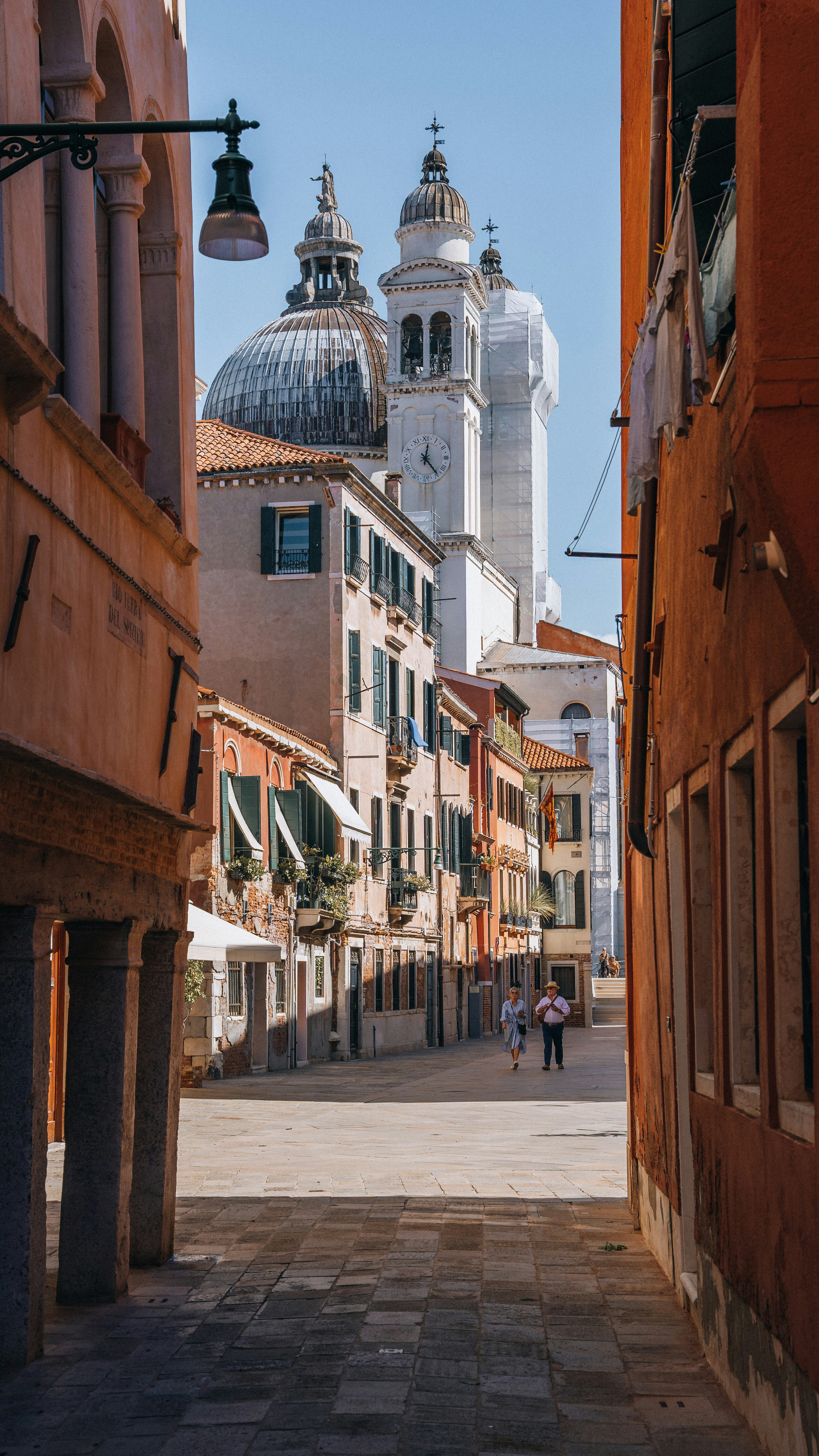 a narrow street with a church in the background