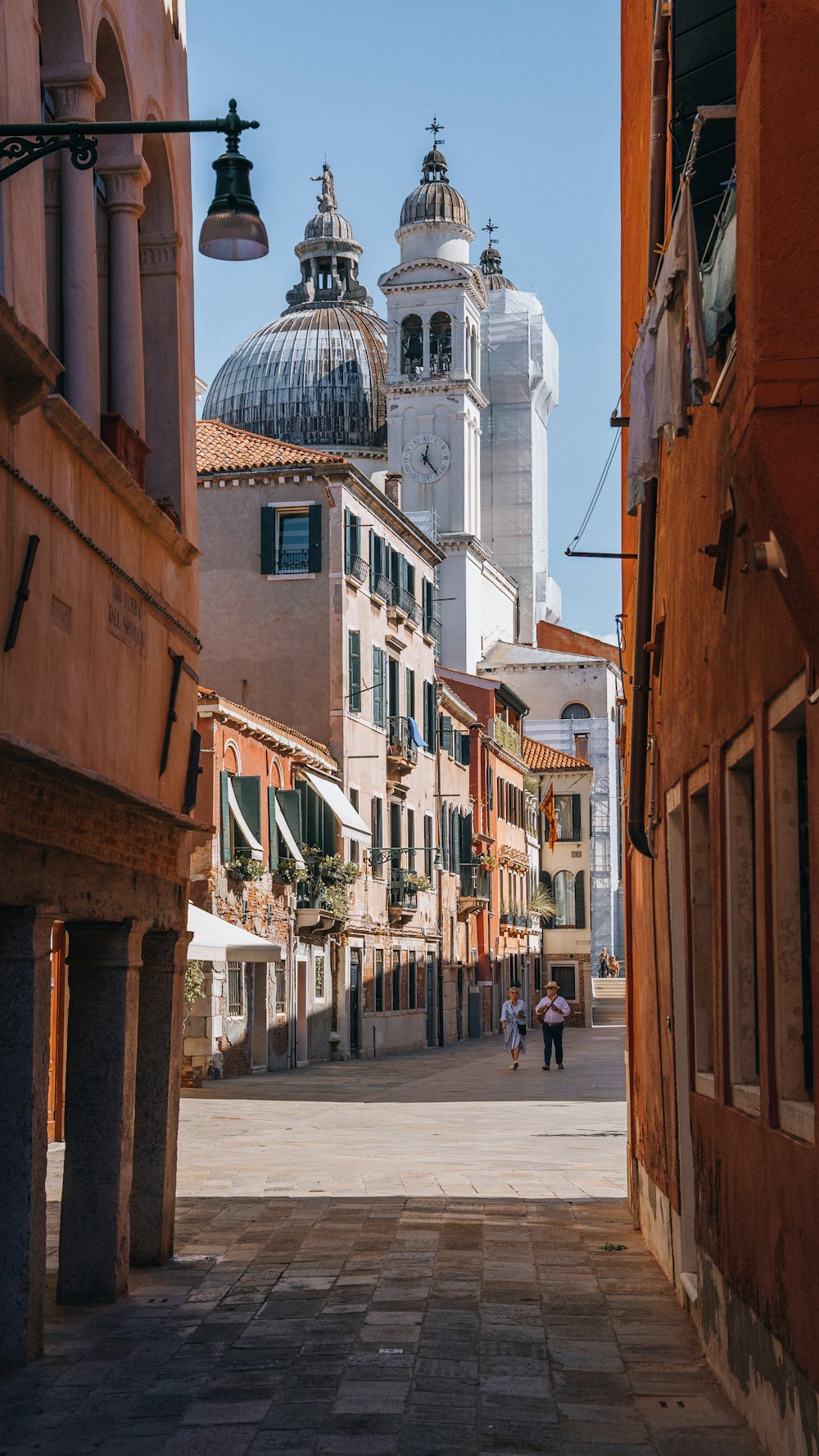 a narrow street with a church in the background