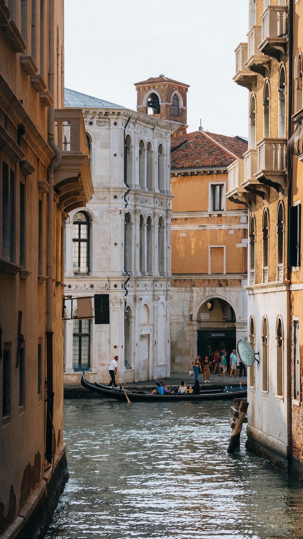 a narrow canal with buildings and people in it