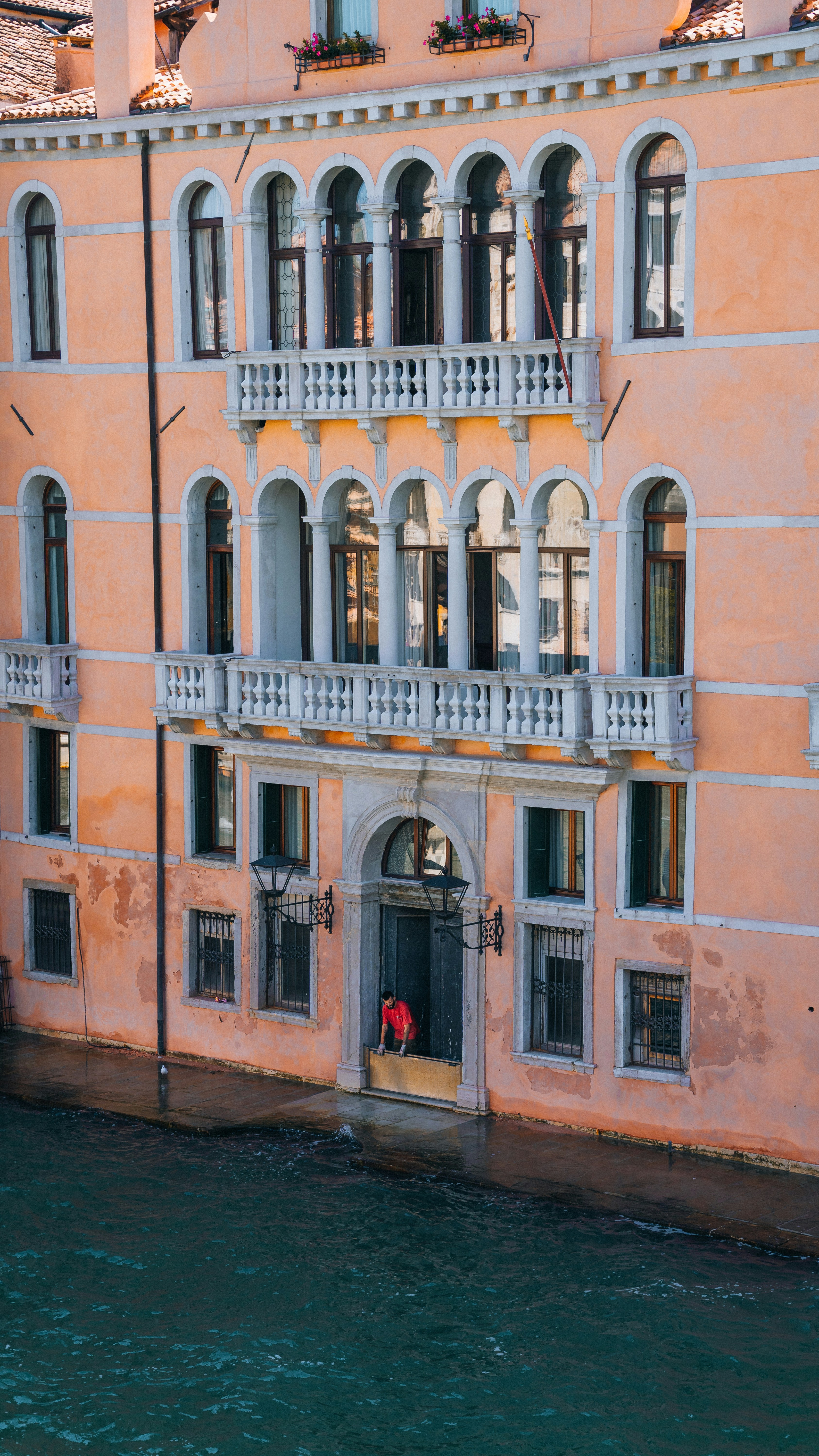 a building with a balcony and balconies next to a body of water