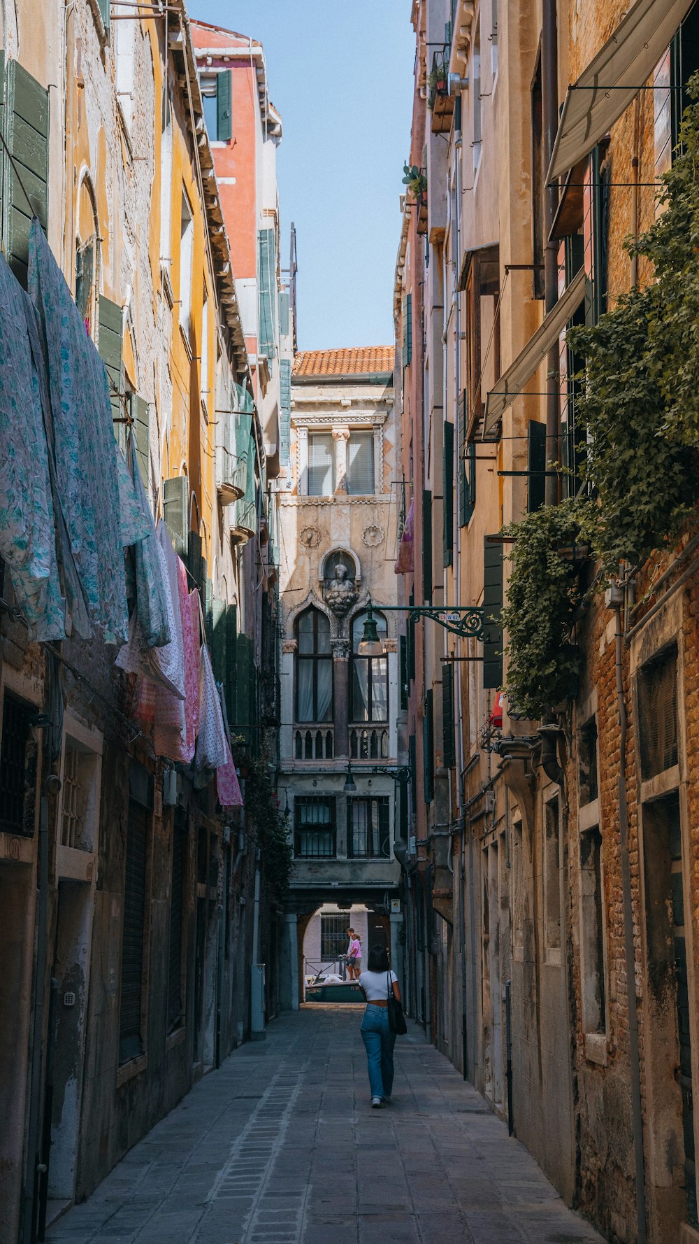 a woman walking down a narrow alley way