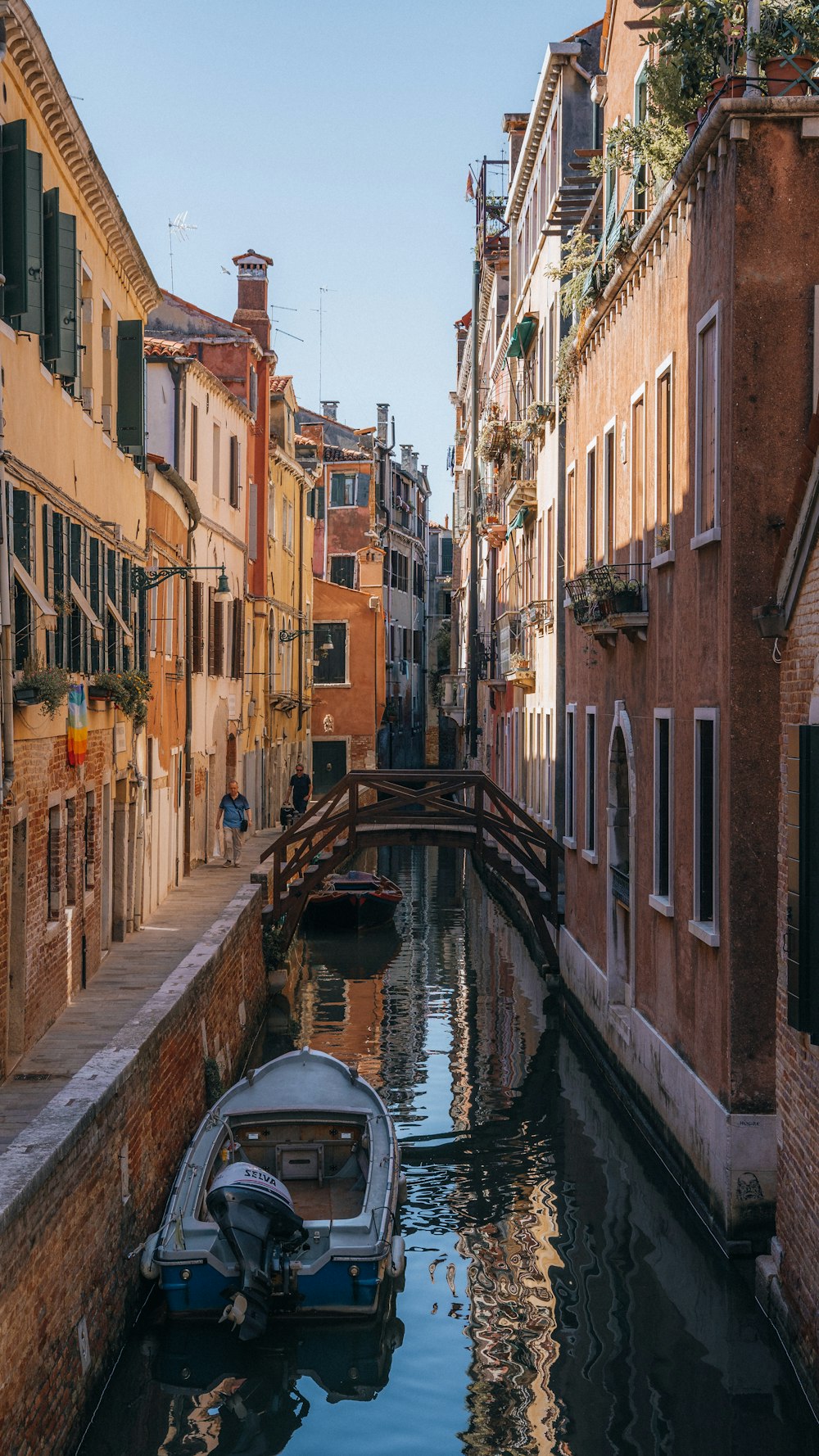 a small boat floating down a narrow canal