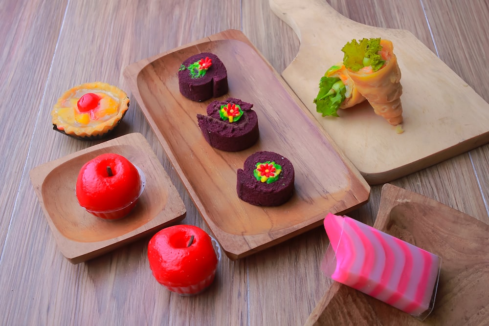 a couple of trays filled with cakes on top of a wooden table