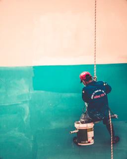 a man is painting a wall with a paint roller
