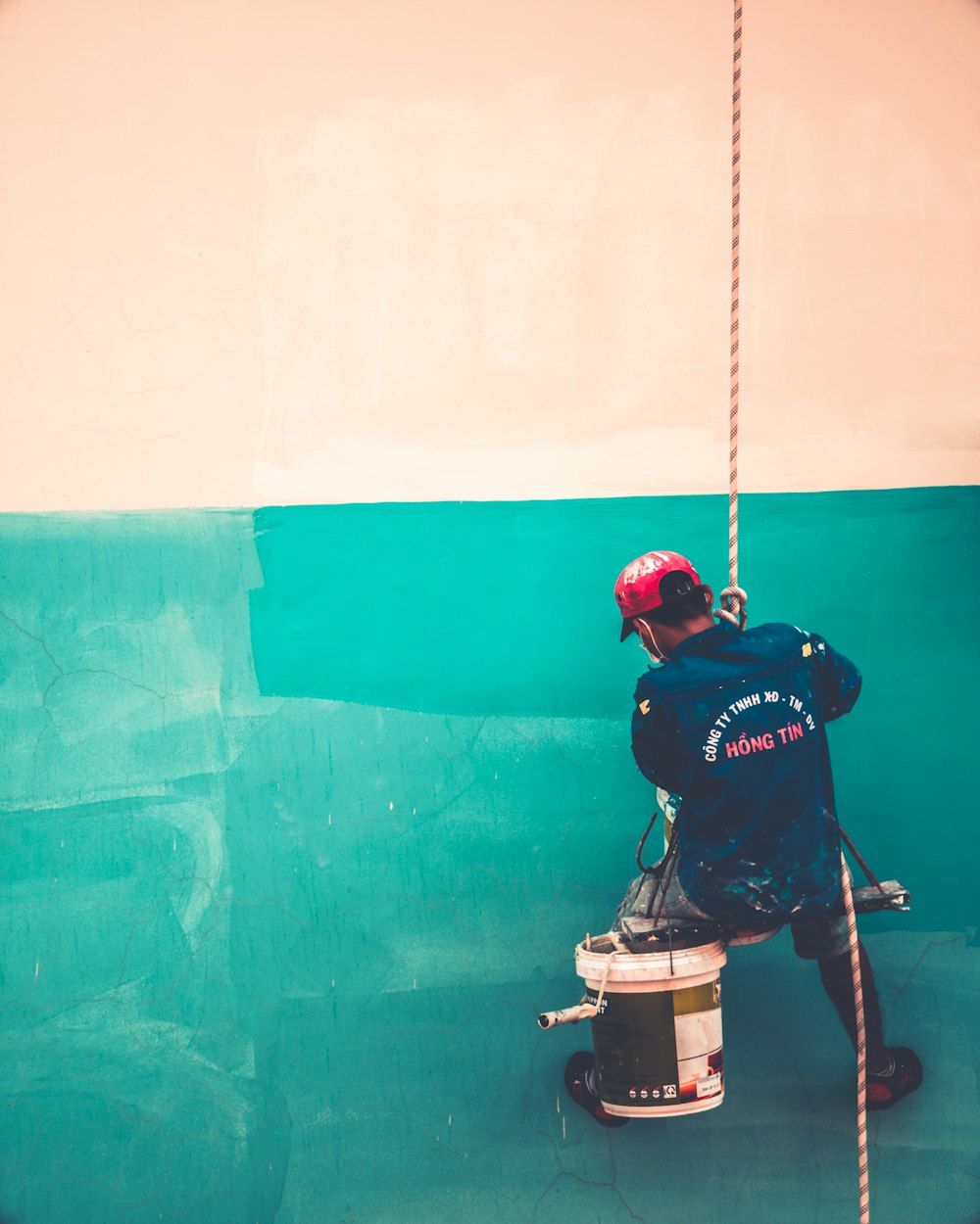 a man is painting a wall with a paint roller