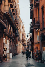 a person walking down a street next to tall buildings