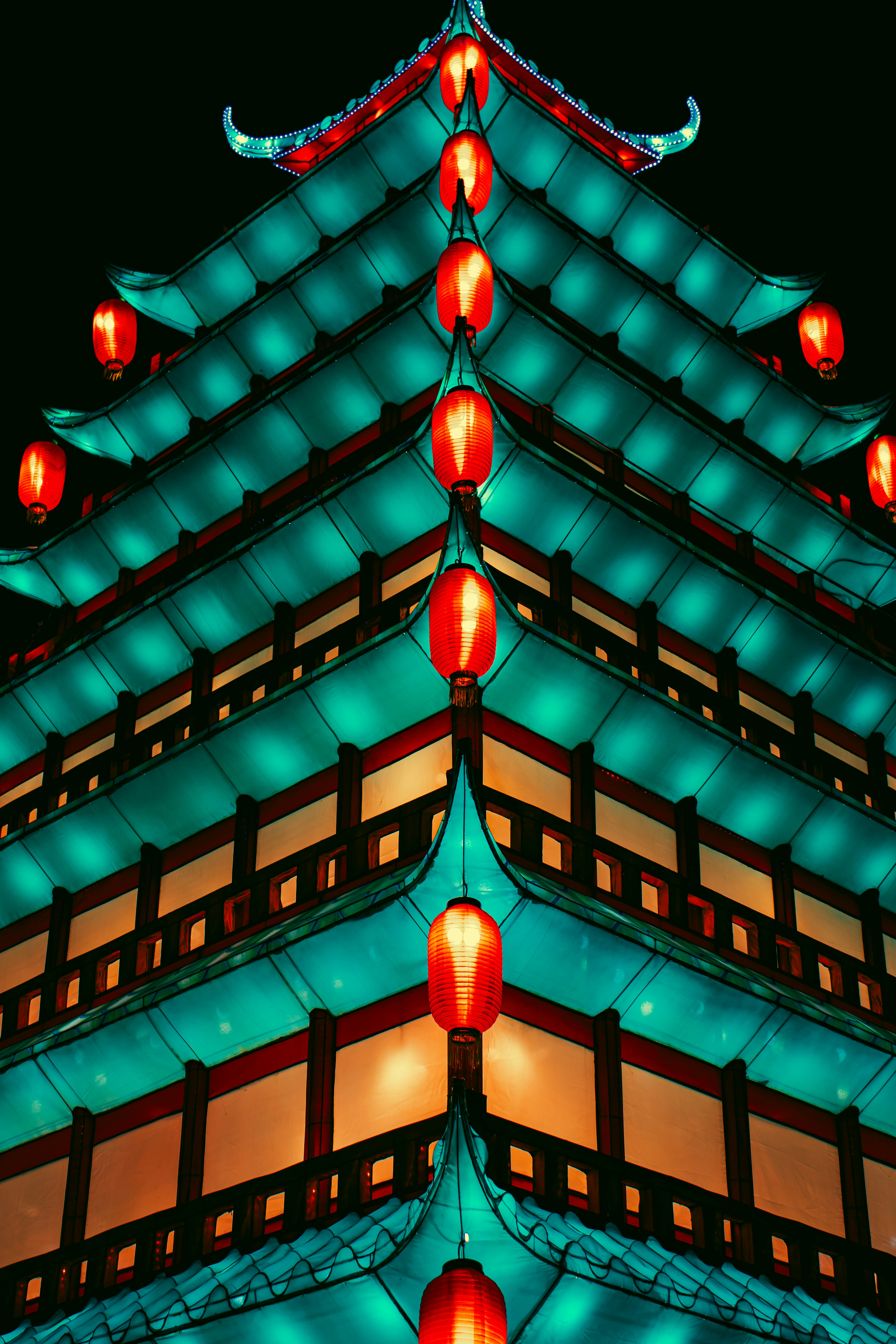 a tall building with red lanterns hanging from it's sides