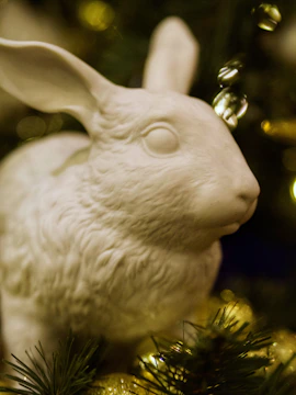 Softly lit image of a white jade rabbit pendant resting on fabric