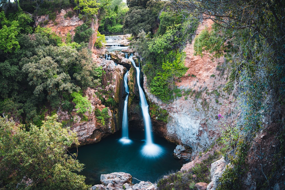 a waterfall with a blue pool in the middle of it