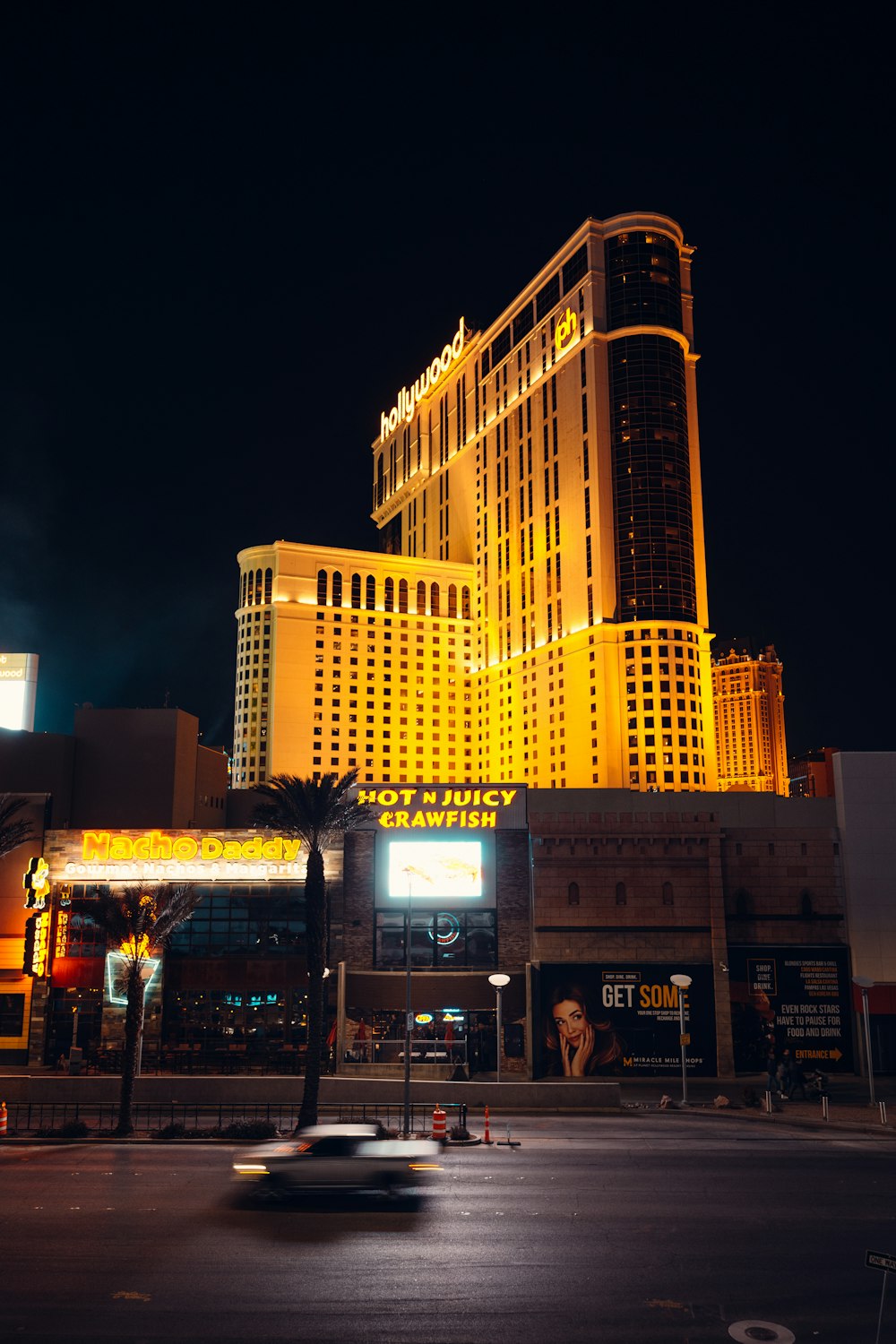 a car driving down a street in front of a tall building