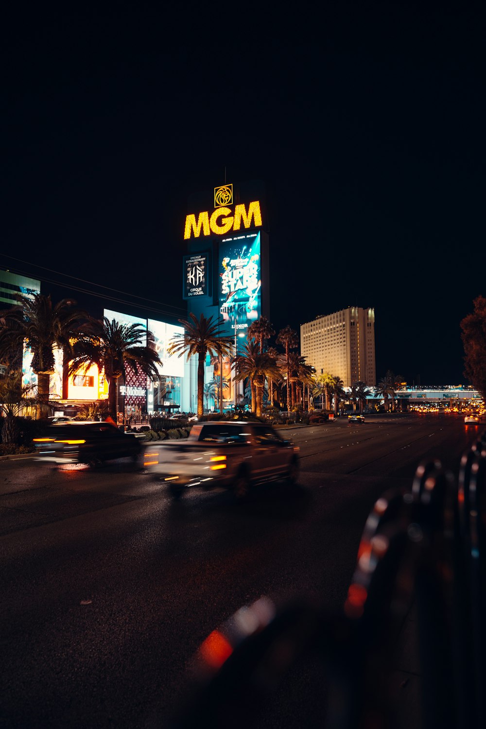 a busy city street at night with a neon sign