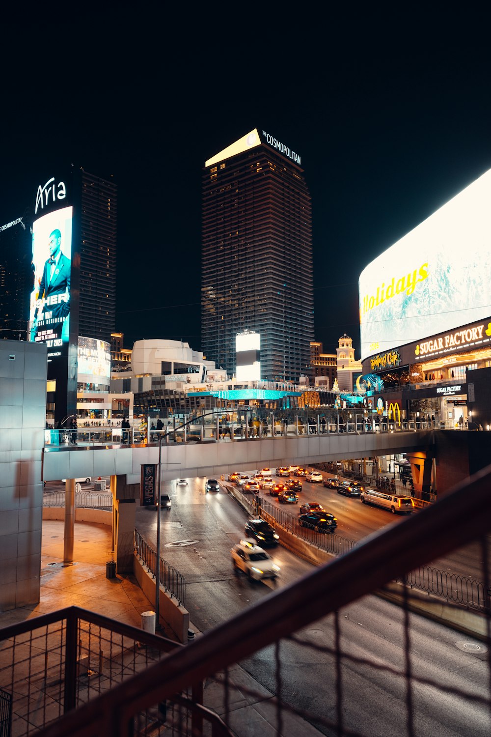 a busy city street at night with tall buildings