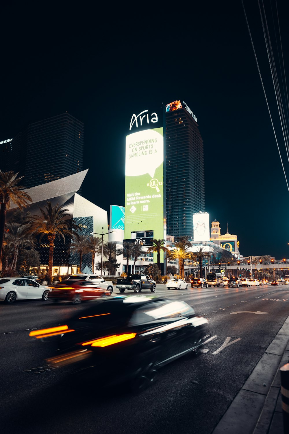 a busy city street at night with cars passing by