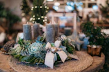 A close-up of a luxury centerpiece combining candles and fresh greenery.