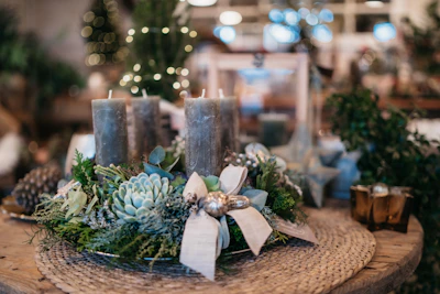 A close-up of a luxury centerpiece combining candles and fresh greenery.