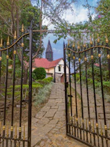 A charming cobblestone path leading to a historic church entrance framed by greenery.
