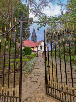 A charming cobblestone path leading to a historic church entrance framed by greenery.