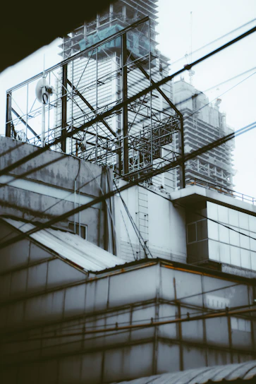 Wide shot of a construction site with cranes and electrical wiring being installed on steel frameworks.