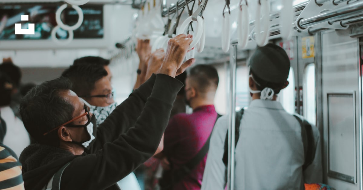 A group of people riding on a train next to each other photo – Free ...