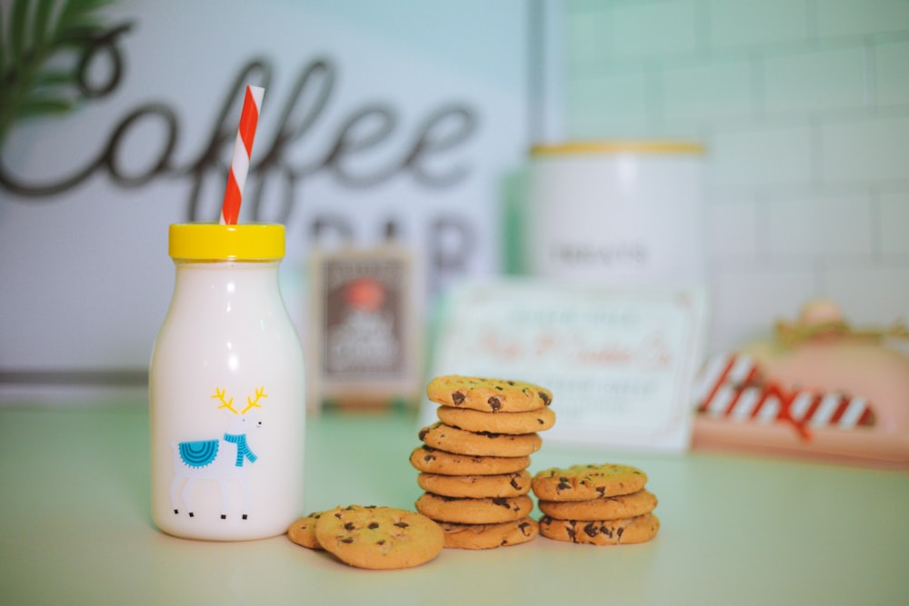 a stack of cookies next to a bottle of milk