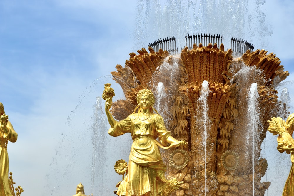 a fountain with gold statues and water spouting out of it