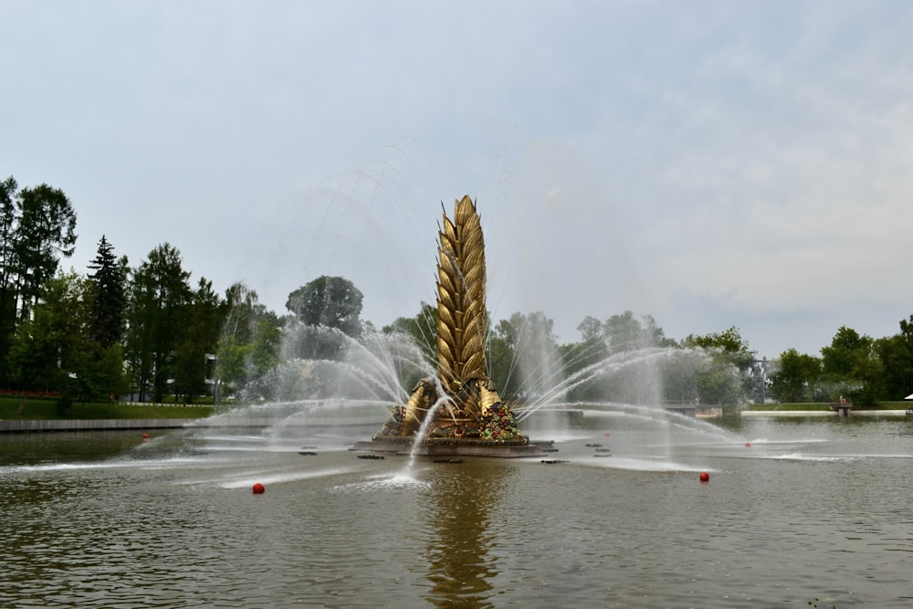 ein Brunnen mit einer großen goldenen Skulptur in der Mitte