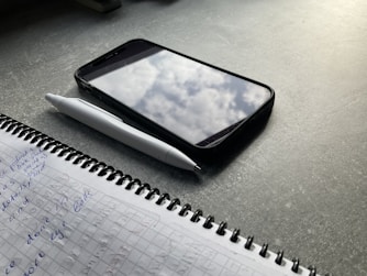 An open notebook filled with sketches and notes about the magical phone’s powers.