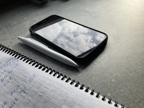 An overhead shot of a notebook filled with handwritten notes and sketches about daily phenomena.