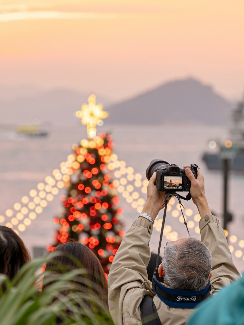 a man taking a picture of a christmas tree