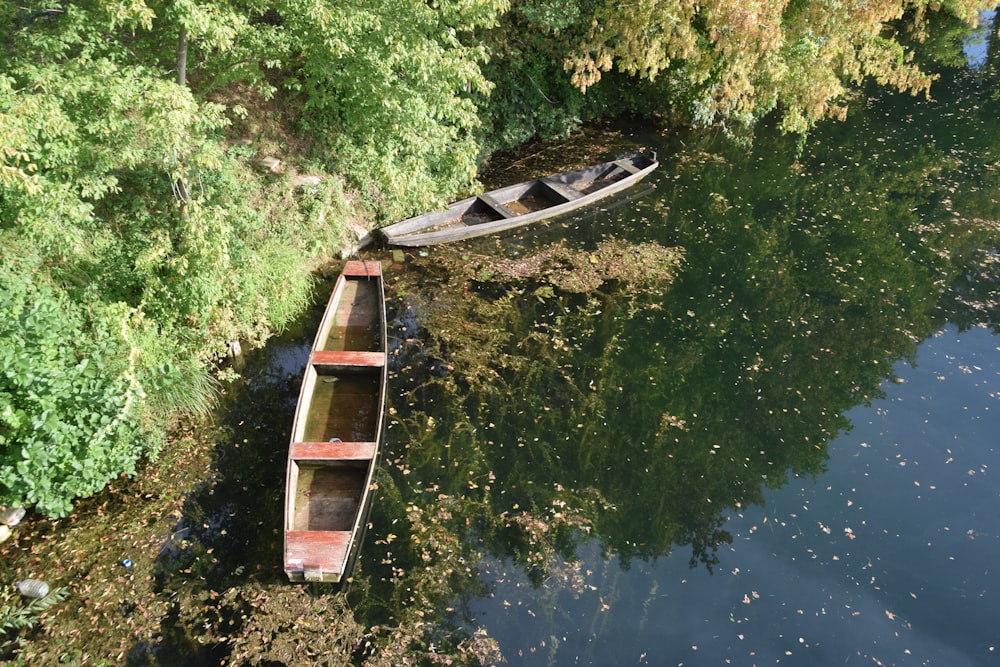 a row boat sitting on top of a river next to a forest