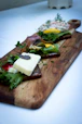 a wooden cutting board topped with different types of food