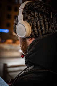a man wearing headphones while looking at a computer screen
