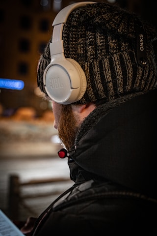 a man wearing headphones while looking at a computer screen