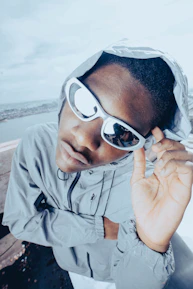 Athlete wearing lúmina sunglasses mid-action with city skyline blurred in background.