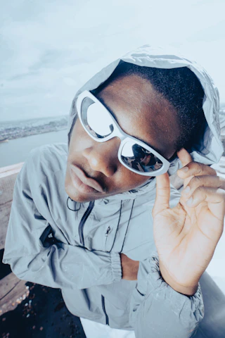 Athlete wearing lúmina sunglasses mid-action with city skyline blurred in background.