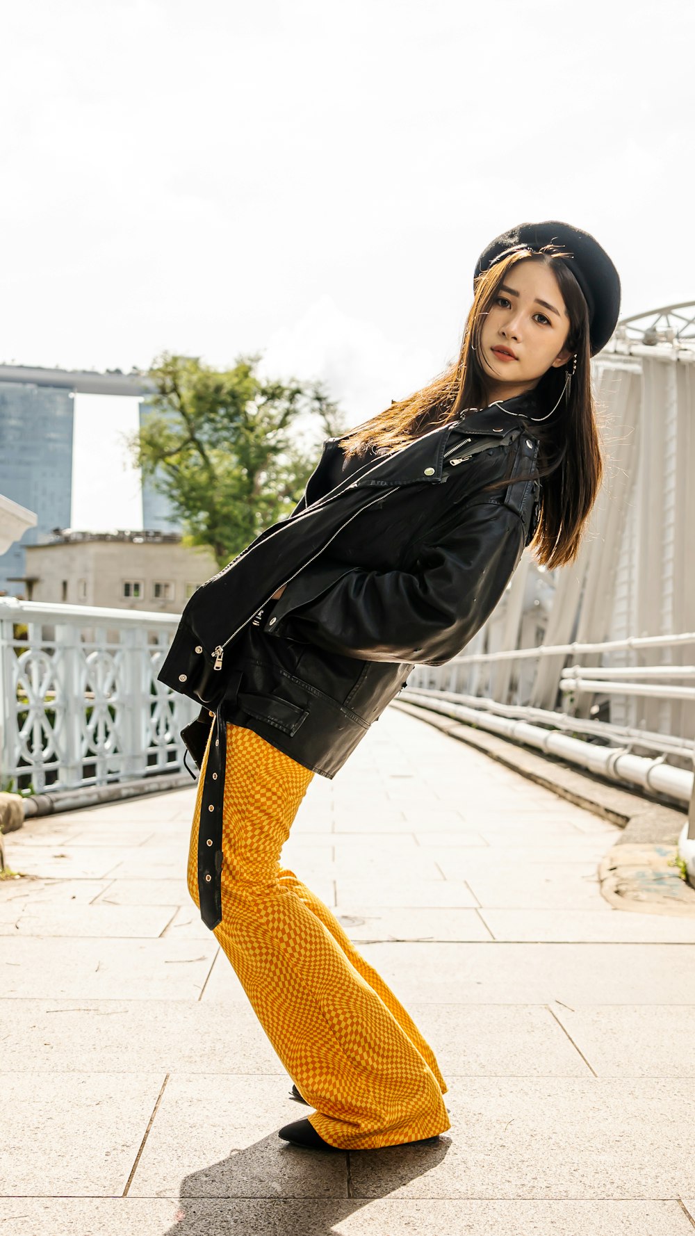 a woman in yellow pants and a black jacket