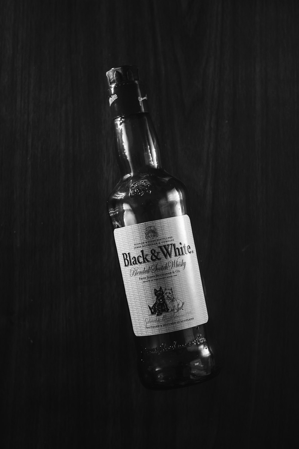 a black and white photo of a bottle of wine