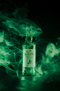 Artistic shot of white and black swirling smoke blending with a sleek perfume bottle.