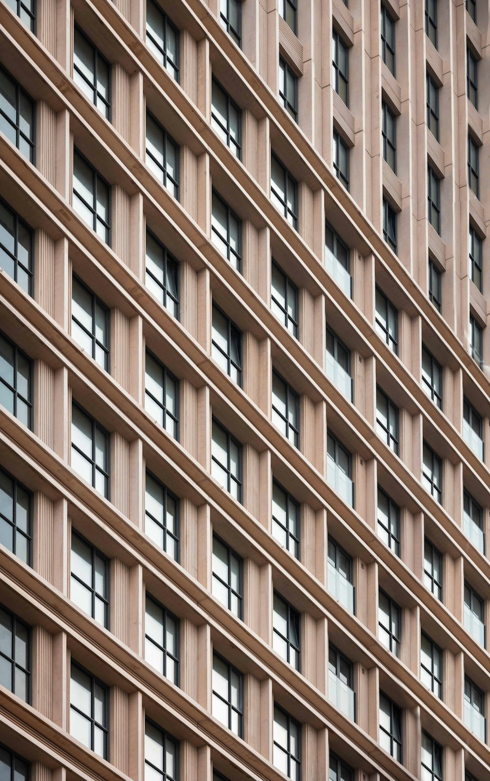 Un edificio alto con molte finestre accanto a un orologio