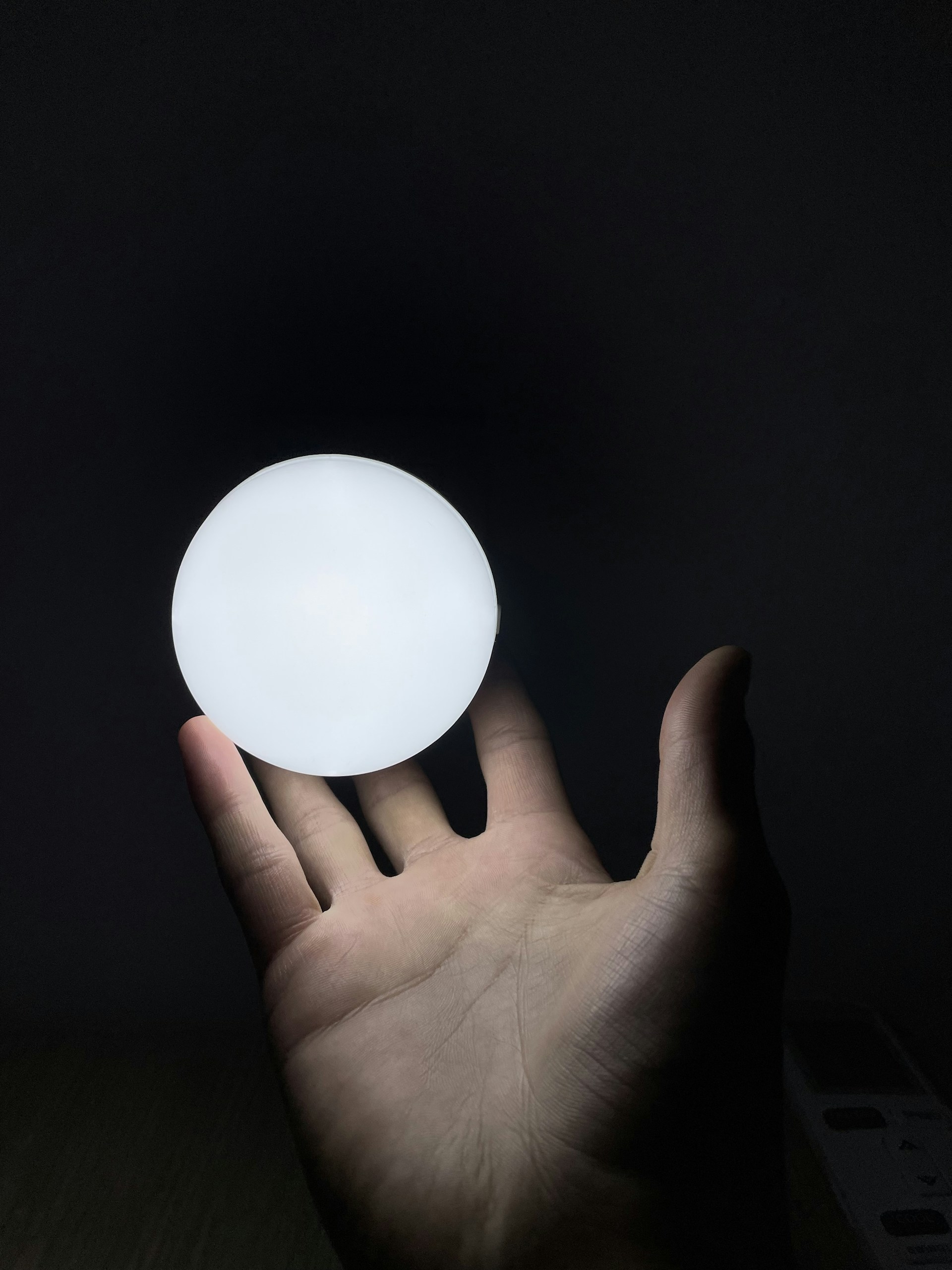 A gentle hand holding a glowing amulet against a backdrop of swirling spiritual energy and deep indigo hues.