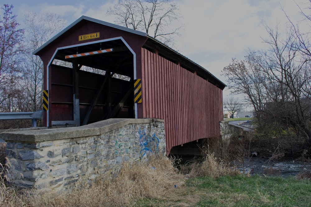 a covered bridge over a small stream in a rural area